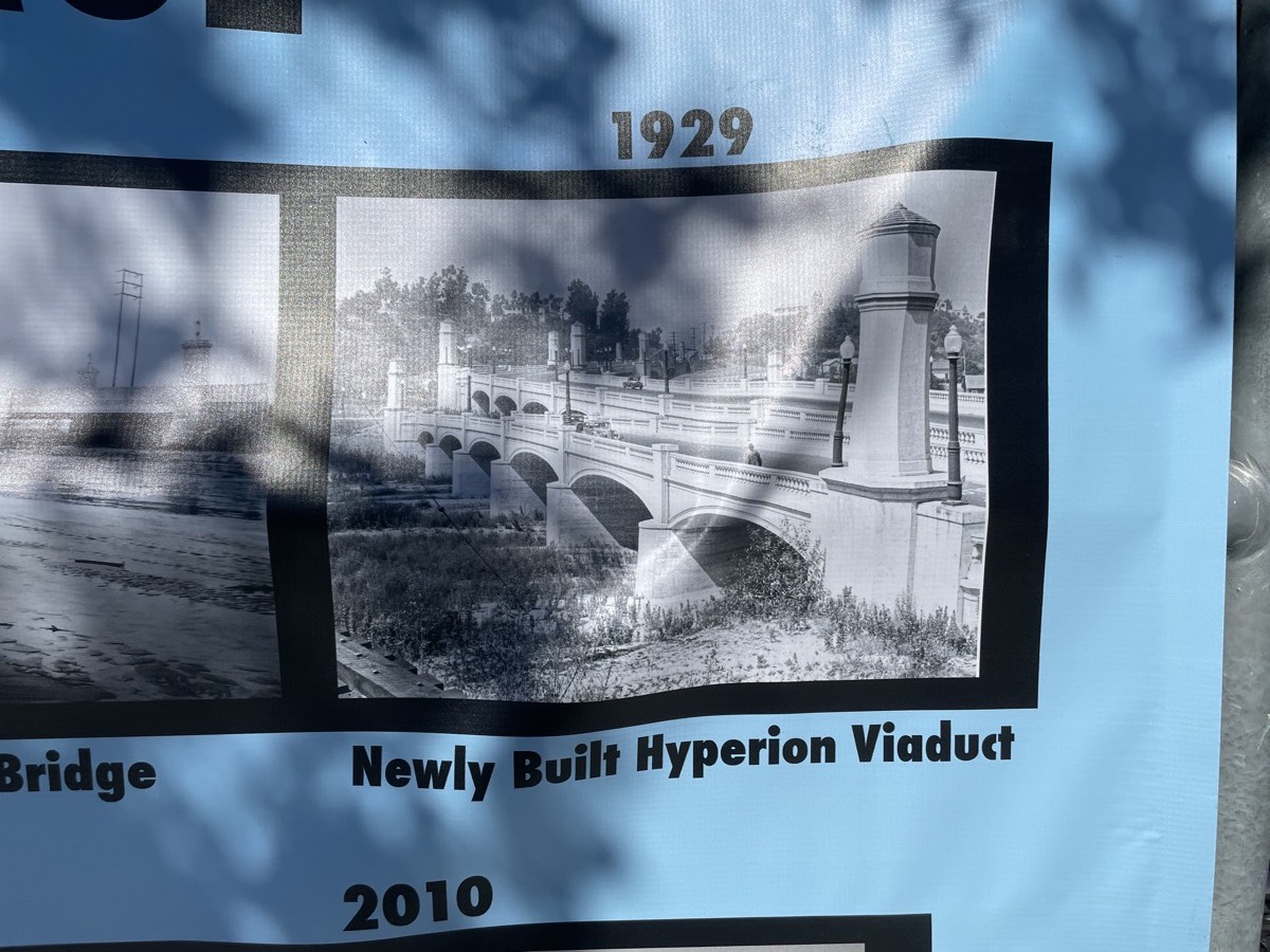 A vinyl banner showing an archival photo. It reads “1929, Newly Built Hyperion Viaduct.”